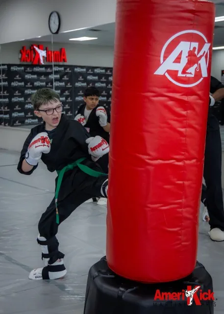 Kids Martial Arts student drilling combinations on bag